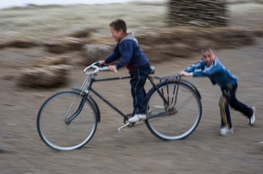 nomadic boys play with a old bike