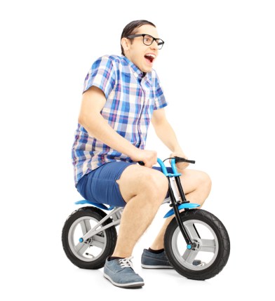 Excited young male riding a small bicycle